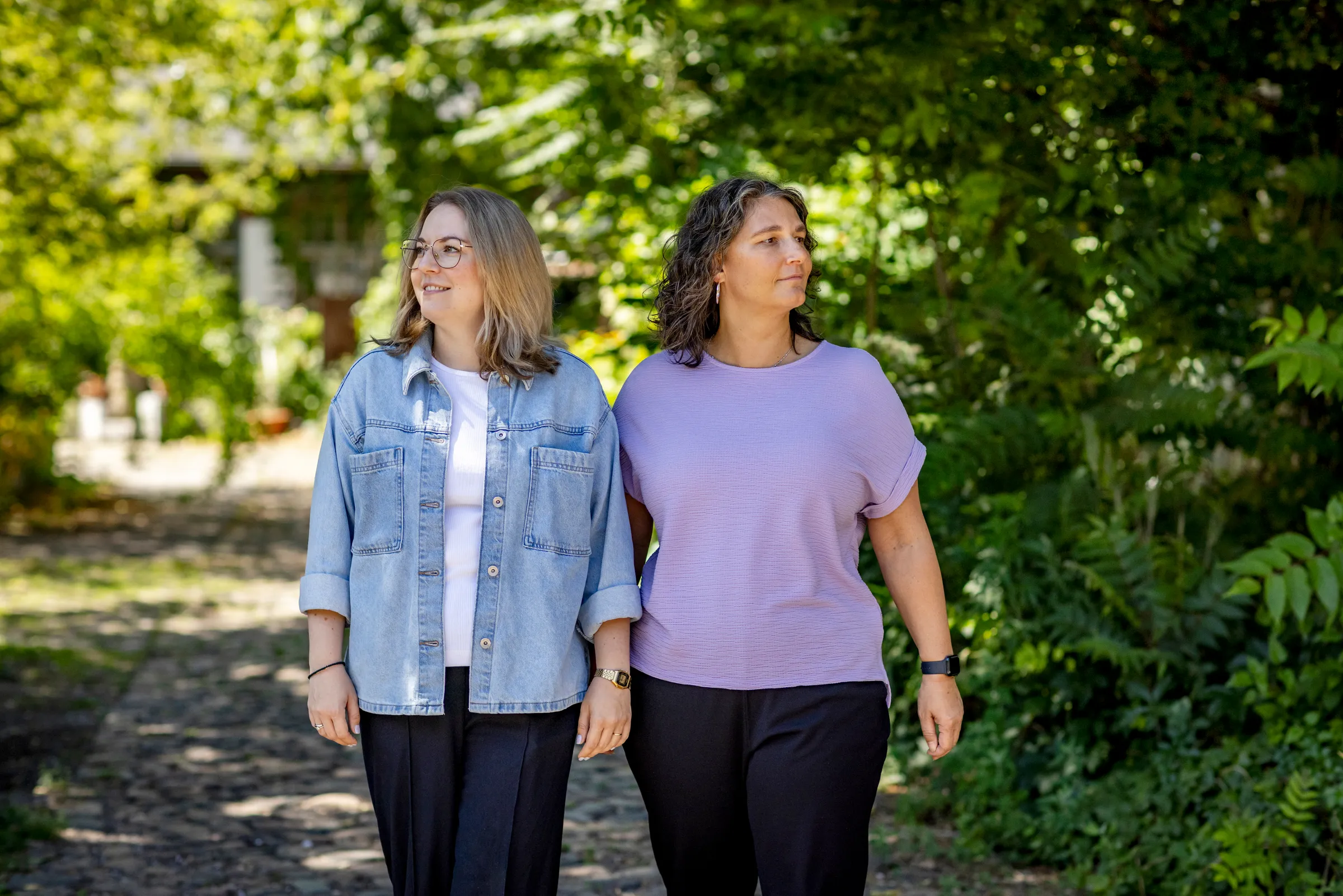 Katja Beckmeyer und Dominique Woith gehen nebeneinander einen Gartenweg entlang