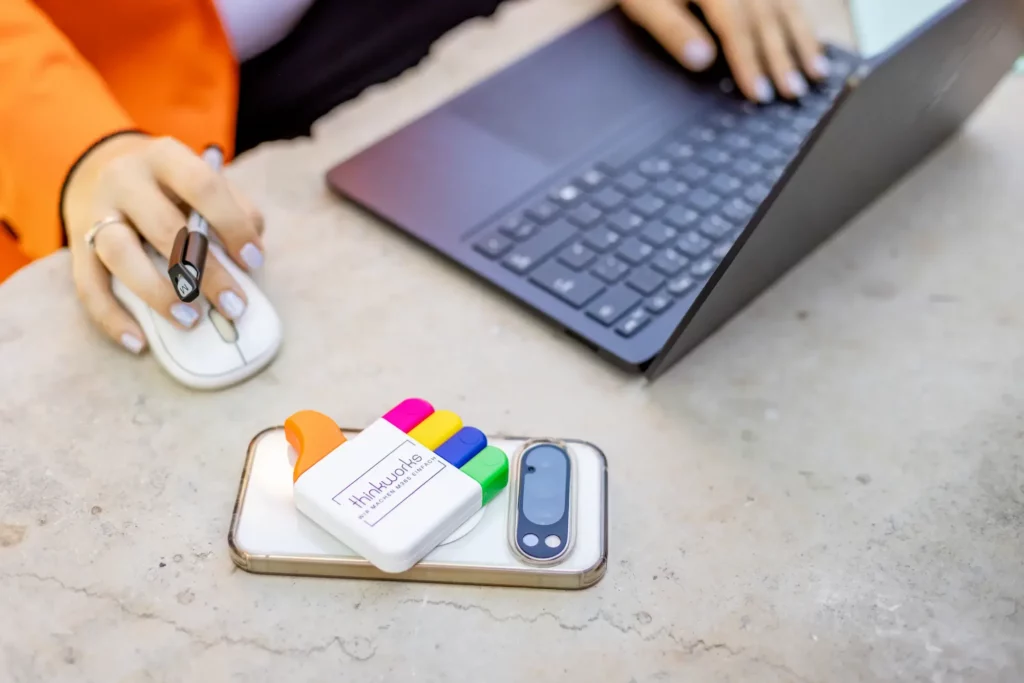 Laptop, Maus und thinkworks-Textmarker auf einem Smartphone