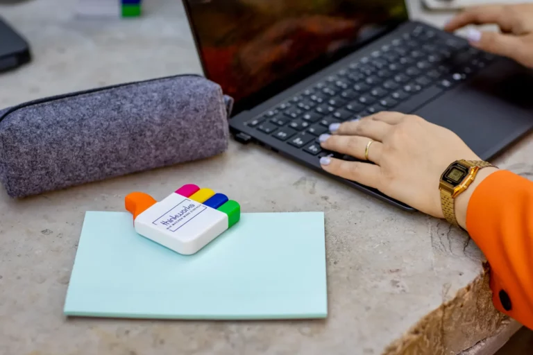Hände tippen auf einem Laptop, daneben ein thinkworks-Textmarker auf einem Notizblock