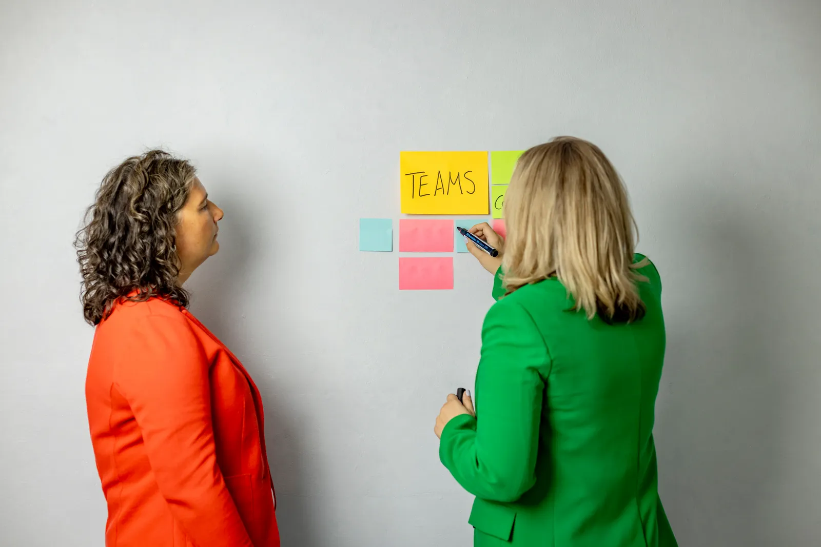 Katja Beckmeyer und Dominique Woith ordnen Haftnotizen unter der Überschrift „Teams“